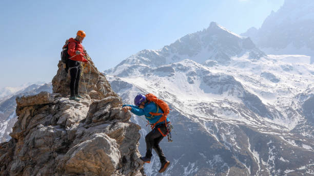 istock Mountaineering couple scramble to summit together 1336735698