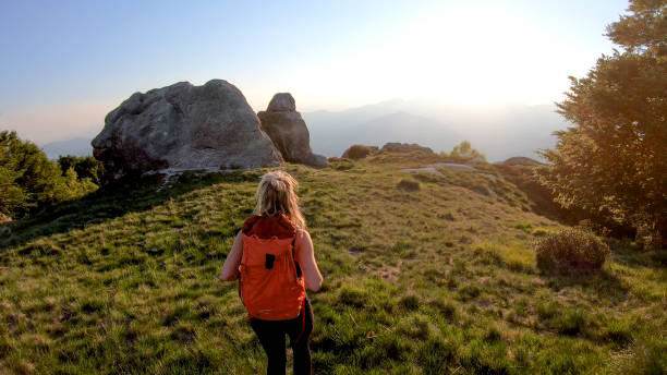 istock Young woman backpacker hikes into sunlight on a mountain ridge 1336737308