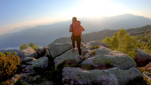 istock Young woman backpacker hikes into sunlight on a mountain ridge 1336737309