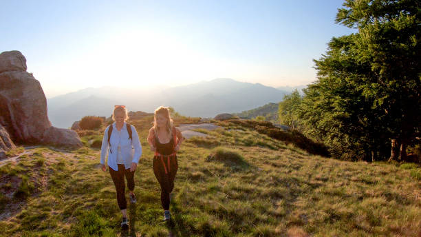istock Two women backpackers hike into sunlight on a mountain ridge 1336737892