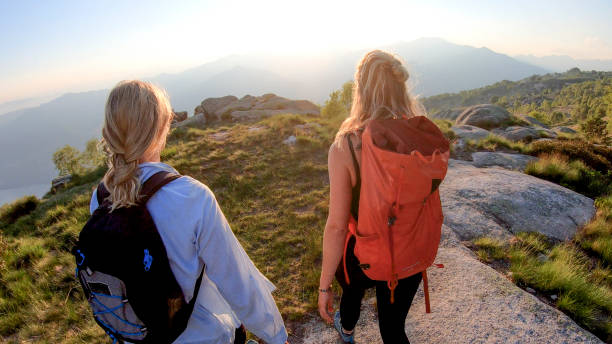 istock Two women backpackers hike into sunlight on a mountain ridge 1336737938