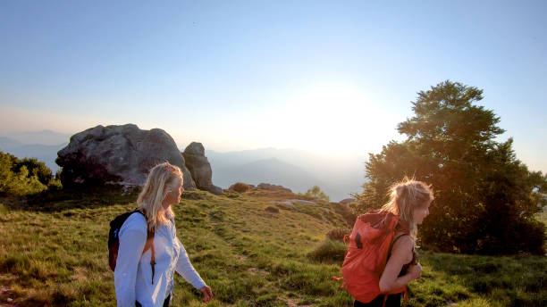 istock Two women backpackers hike into sunlight on a mountain ridge 1336738072