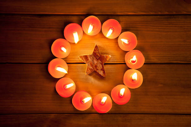 istock christmas candles circle over wood and symbol 1336740457