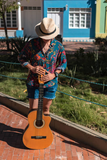 istock Woman with guitar standing in a park 1336748465