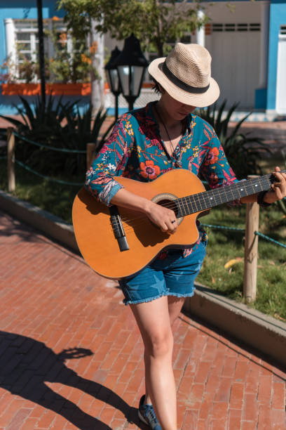 istock Woman playing guitar while walking in the park 1336748846