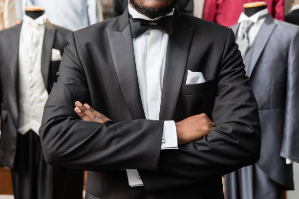 detail of arms crossed of african-american man man dressing tuxedo at tailor ahop - smoking imagens e fotografias de stock