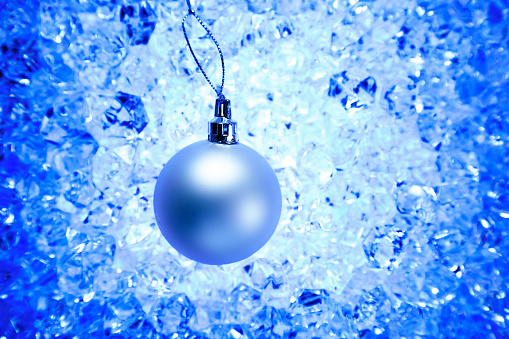 christmas silver bauble on blue winter ice background
