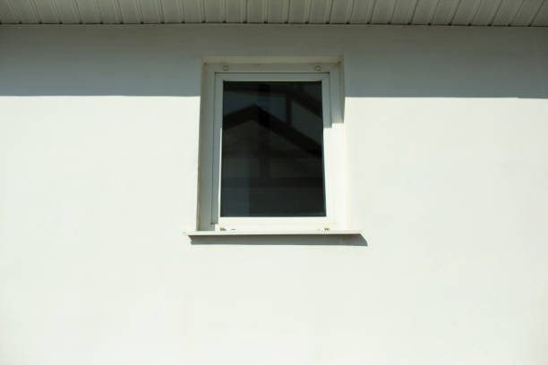 istock White window in a white wall. A small window made of plastic in bright sunlight. Exterior of the building. 1336763005