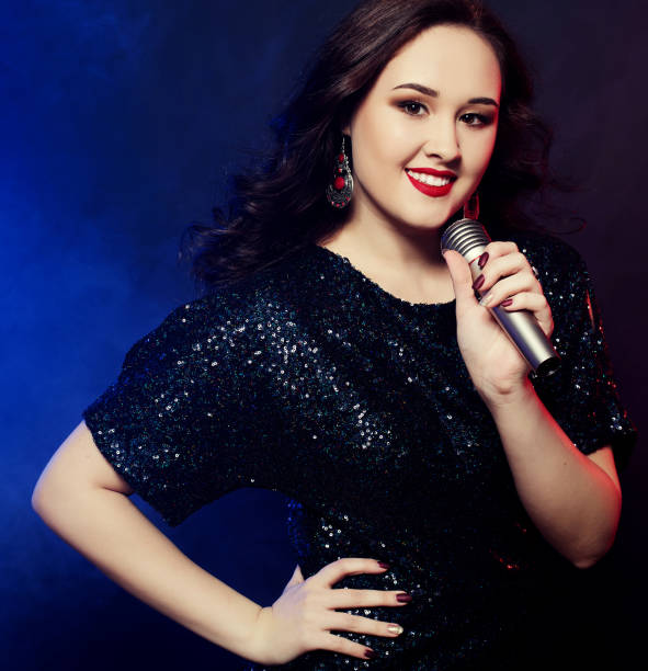istock Young happy girl singing into microphone at party 1336766565