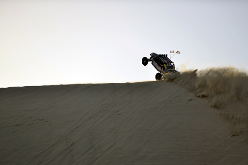 High powered V8 engined Beach Buggies racing with tourists in the afternoon sun in the sand dunes of the Qatari desert, Doha, Qatar.\nQatar is one of the richest countries in the world backed by the world's third-largest natural gas and oil reserves. Qatar offers a wide variety of tourist attractions among others, safari and beach buggy race in the desert.