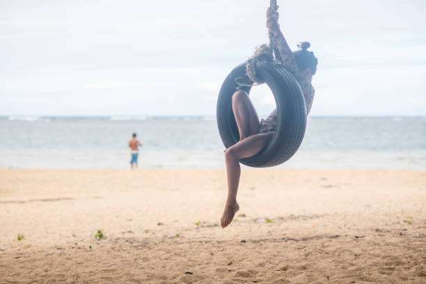 Pretty young woman in tire swing on a summers day