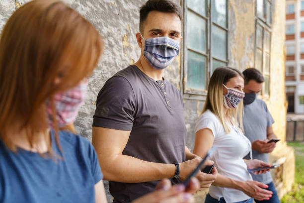 istock Side view on caucasian man and woman using mobile phone - Modern communication online texting social network messaging - Men and woman with mask hold mobile phones - social distance new normal concept 1336776022