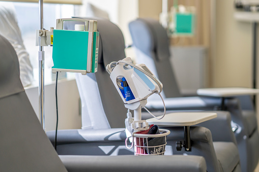 A photo showing an empty chemotherapy treatment room. The room has arm chairs and medical machines and supplies.