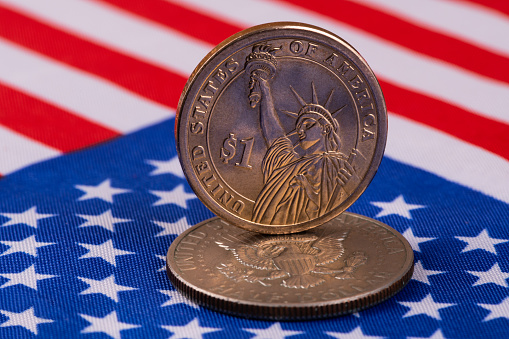 1 American dollar coins on the background of the US national flag