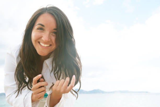 istock woman smiling at the beach on a sunny day 1336794252
