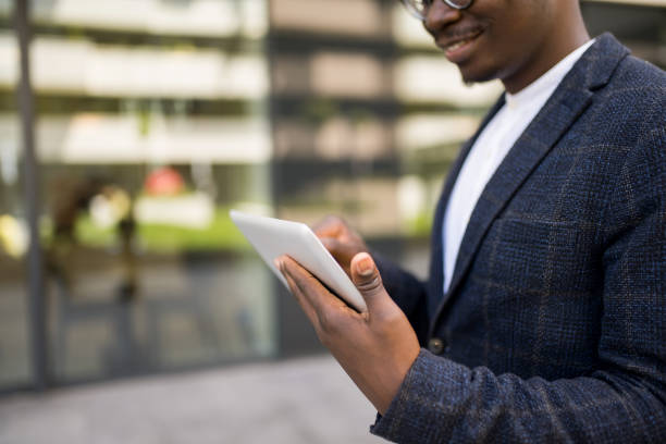 istock Happy young businessman using digital tablet outside of an office building. 1336794529