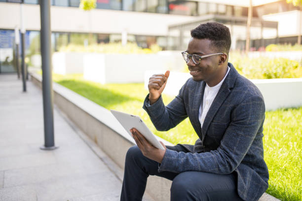 istock Happy young businessman using digital tablet outside of an office building. 1336794549