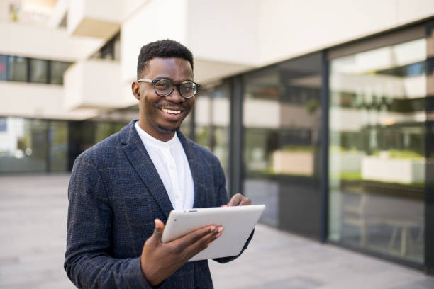 istock Young businessman using digital tablet outside of an office building. 1336795193