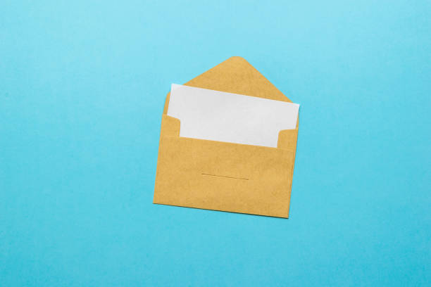 istock An open postal envelope with an enclosed white sheet on a blue background. Flat lay. 1336803487