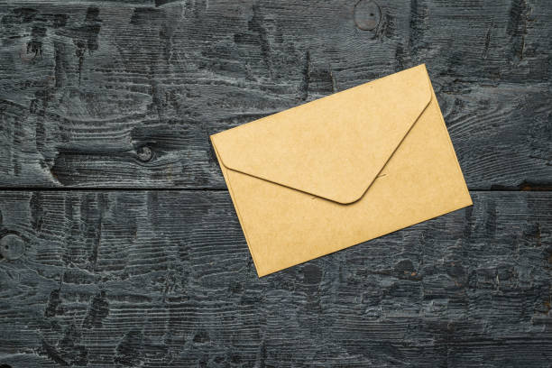 istock A paper postal envelope on a wooden table. Flat lay. 1336803496