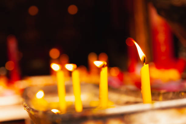 istock closeup yellow candle with fire and flame in dark 1336809681