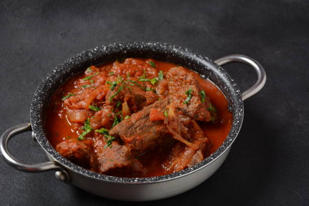 istock Beef meat stew. Overhead view braised beef meat stew in tomato sauce with herbs 1336810850