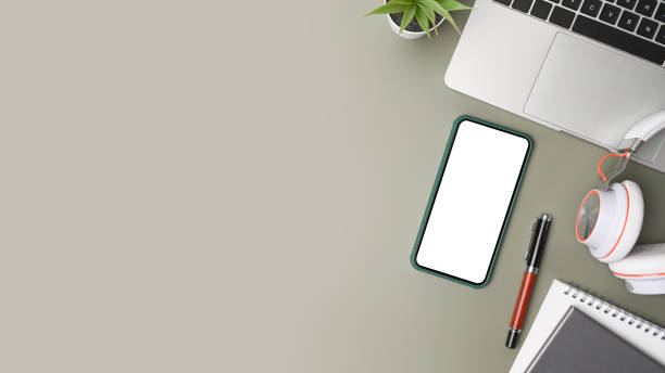 istock Above view smart phone with blank screen and laptop on gray background. 1336814275