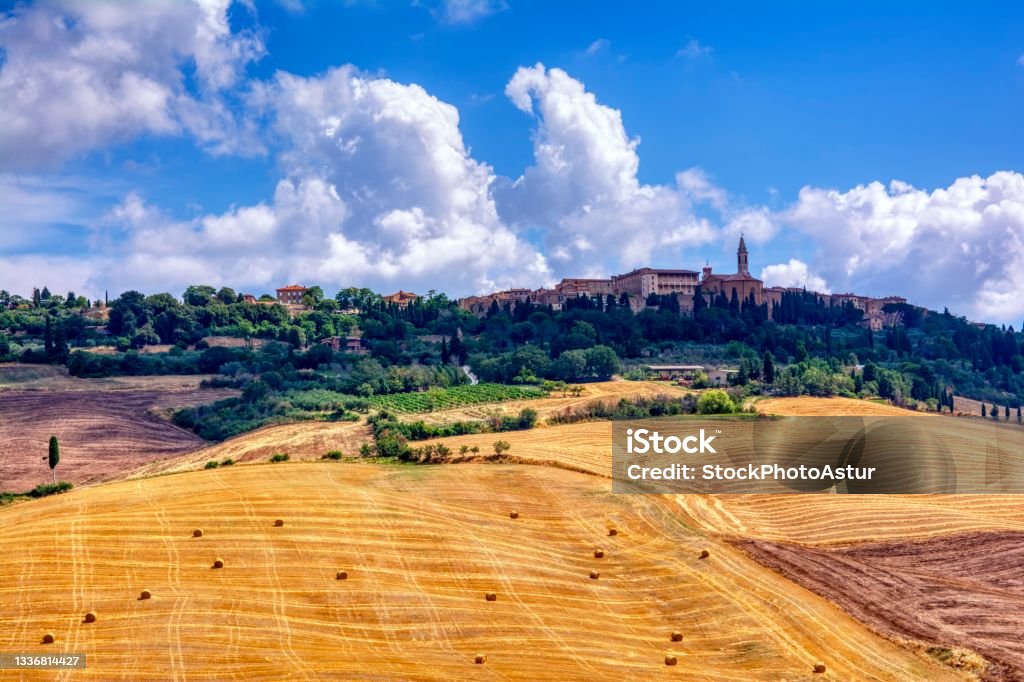 Tuscan landscape . Tuscan landscape with fields full of grain bales with San Quirico de Orcia in the background. San Quirico D'orcia Stock Photo
