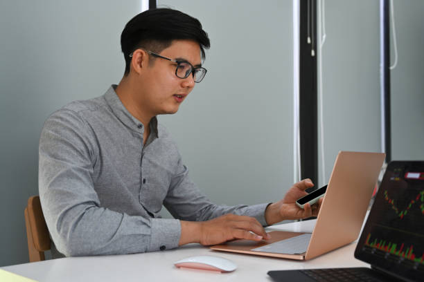 istock Smart businessman using mobile phone and working with laptop at his workplace. 1336818102