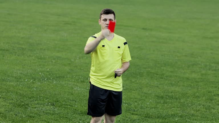 Soccer referee showing red card and removes player . Concept of sport, rules violation, offside.