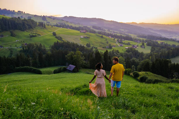 campo de suiza, ebnat kappel, sankt-gallen, suiza, pareja hombre una mujer mirando la puesta de sol fuera de allí pequeña cabaña de la casa sobre los prados de suiza - mountain cabin european alps switzerland fotografías e imágenes de stock