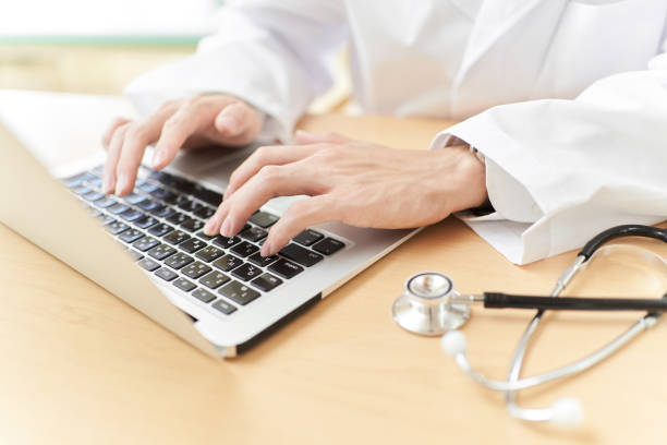 istock Male doctor writing a manuscript on a personal computer 1336827392