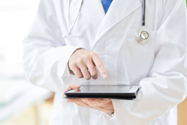 Male doctor operating a tablet