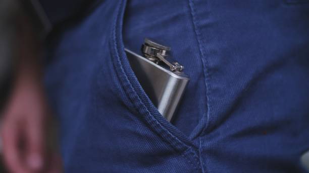 Caucasian Drinking Man Pulling Out and Putting In Shiny Metal Hip Flask of Whiskey Alcohol Concealed in Trousers Pocket Caucasian Drinking Man Pulling Out and Putting In Shiny Metal Hip Flask of Whiskey Alcohol Concealed in Trousers Pocket hipflask stock pictures, royalty-free photos & images