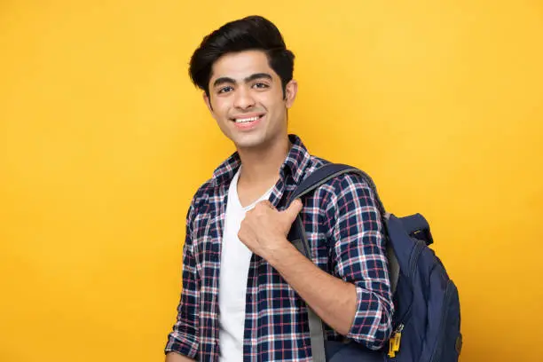 Photo of Male teenage student in yellow background stock photo