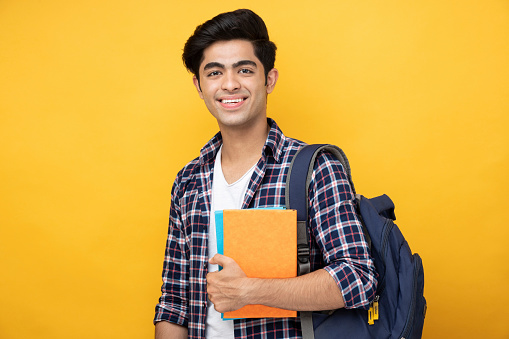 Estudiante adolescente masculino con foto de archivo de fondo amarillo photo