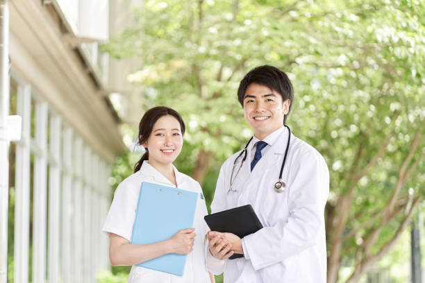 Doctors and nurses standing with a smile on a green background