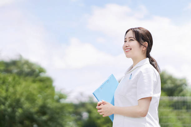 Female nurse standing with a smile on a blue sky background