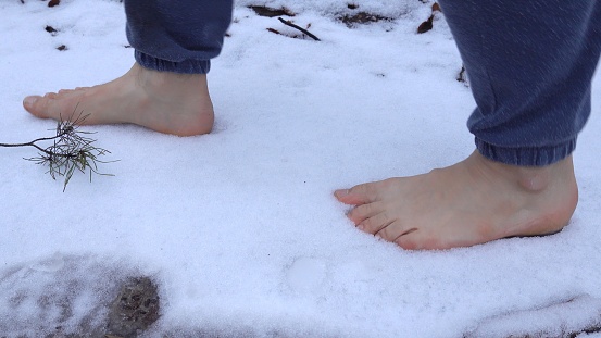 Caucasian Male Walks Barefoot on Snow Leaving Footprints