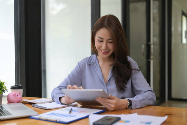 istock Female accountant using digital tablet at office desk. 1336836685