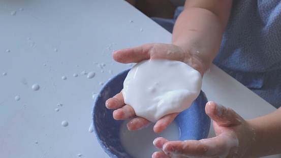 Smart Curious School Kid Playing With Homemade Water and Corn Starch Based Mixture Non Newtonian Oobleck Fluid STEM
