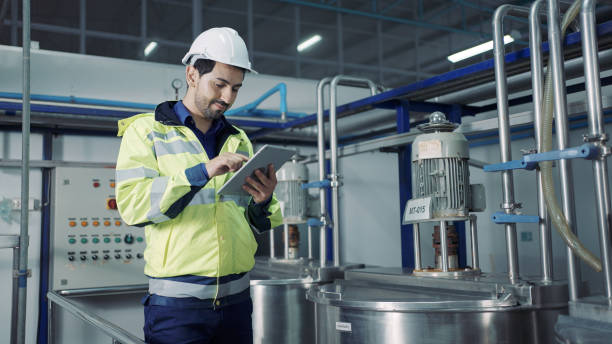 Technician controlling industrial process in plant stock photo