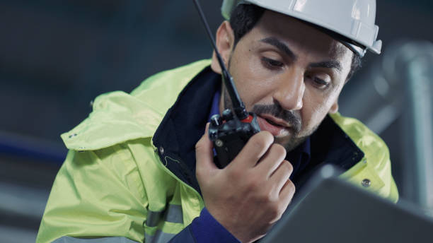 istock Worker holding digital tablet in hand talking on walkie-talkie 1336844497