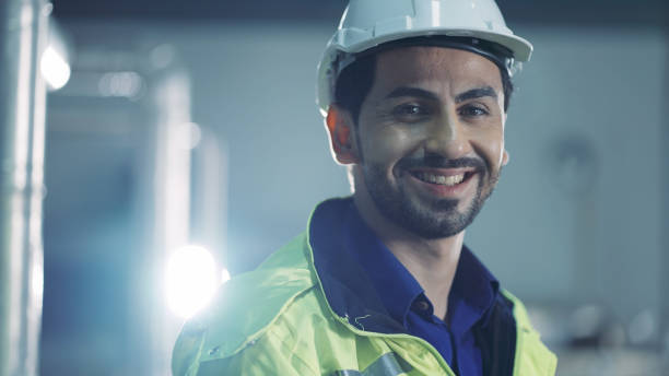 istock Male technician in white hardhat talking on walkie-talkie 1336844530