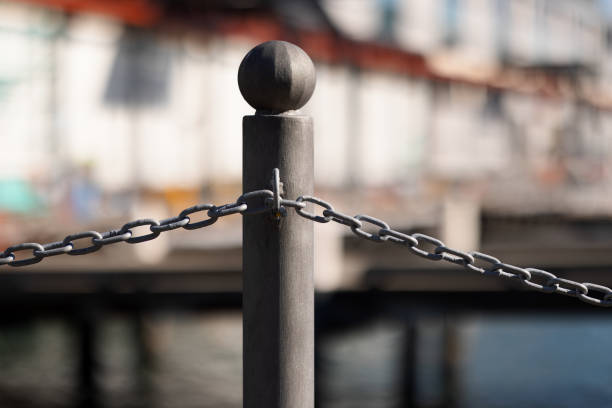 Chained bollard with dock and water scene behind.