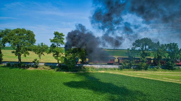 istock Aerial View of Engine Approaching Thru Trees and Farmlands Pulling Passenger Cars 1336857678
