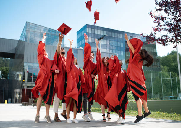 Graduating students hands throwing graduation caps on white background