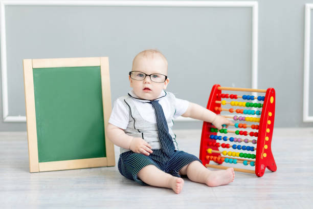 istock baby in glasses with scores and chalk board with space for text, school and learning concept 1336862535