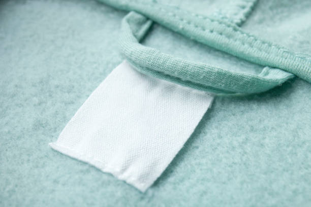 istock Cotton laundry care clothing label on fabric texture with place for text . Clothes with empty label or tag 1336865690
