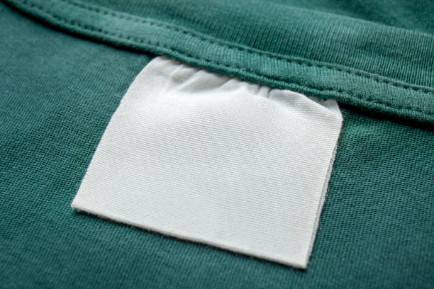istock Cotton laundry care clothing label on fabric texture with place for text . Clothes with empty label or tag 1336865724